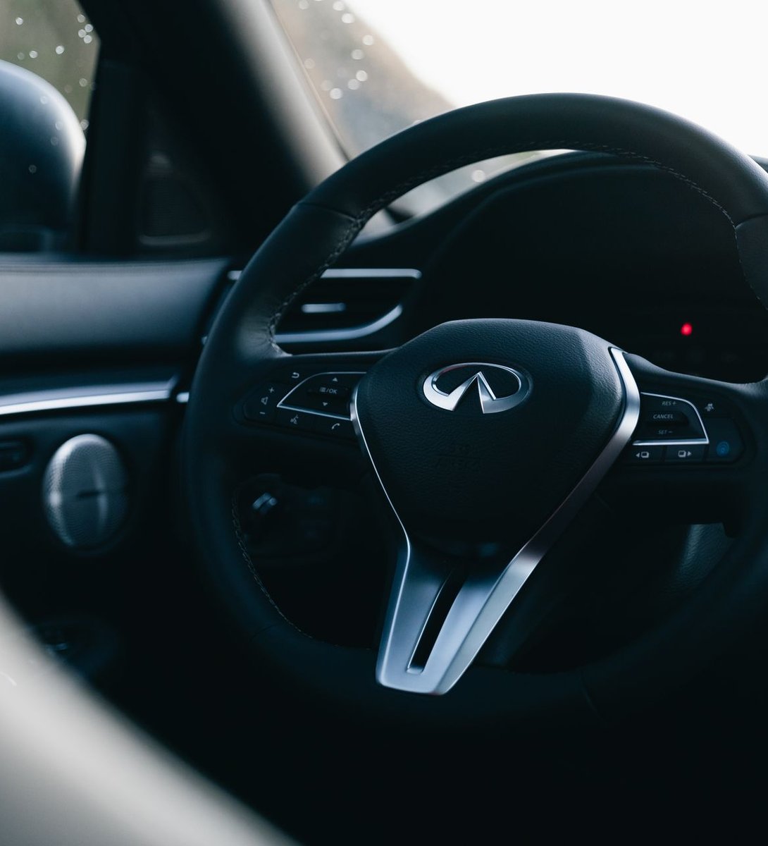 Close-up of a detailed black leather steering wheel and dashboard interior